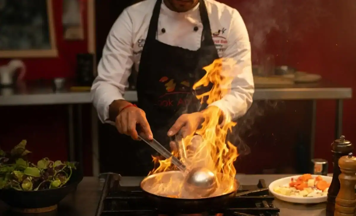 Chef cooking over a flame — wide culinary photograph